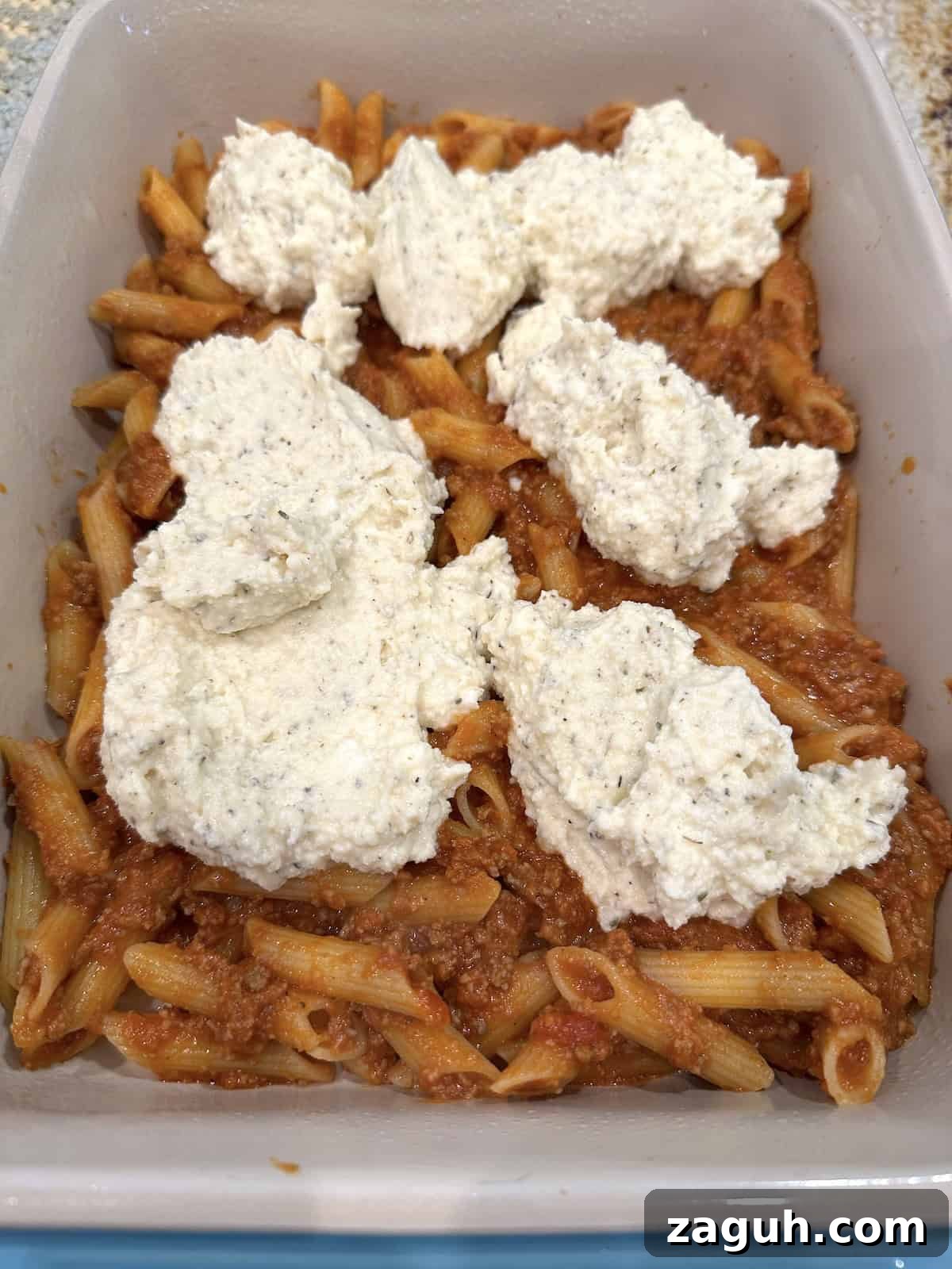 Quick No-Fuss Lasagna Recipe for Busy Weeknights 9 Unbaked lazy lasagna in a baking dish with ricotta cheese on top.
