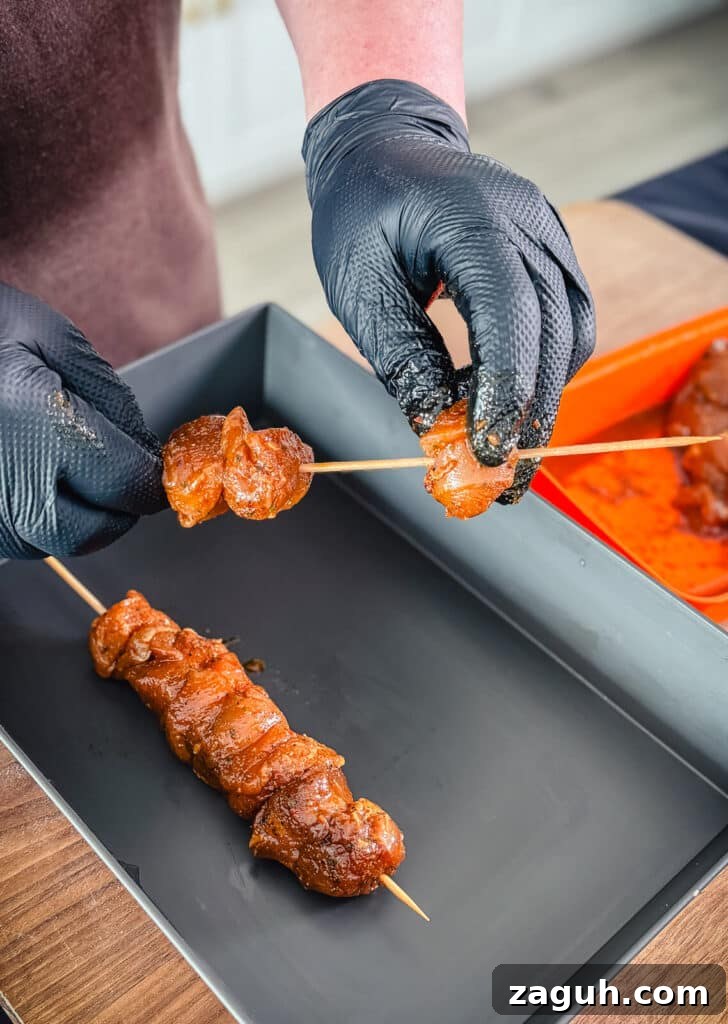 Peruvian-Style Chicken Breast Skewers with Aji Marinade 12 piece of chicken breast being placed onto a skewer