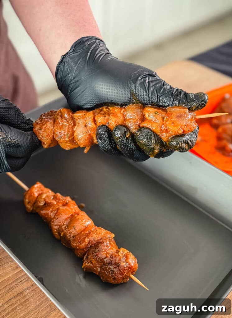 Peruvian-Style Chicken Breast Skewers with Aji Marinade 13 chicken skewer being shaped with a gloved hand