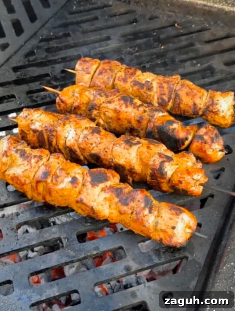Peruvian-Style Chicken Breast Skewers with Aji Marinade 15 charred Peruvian chicken breast skewer on a grill over hot coals