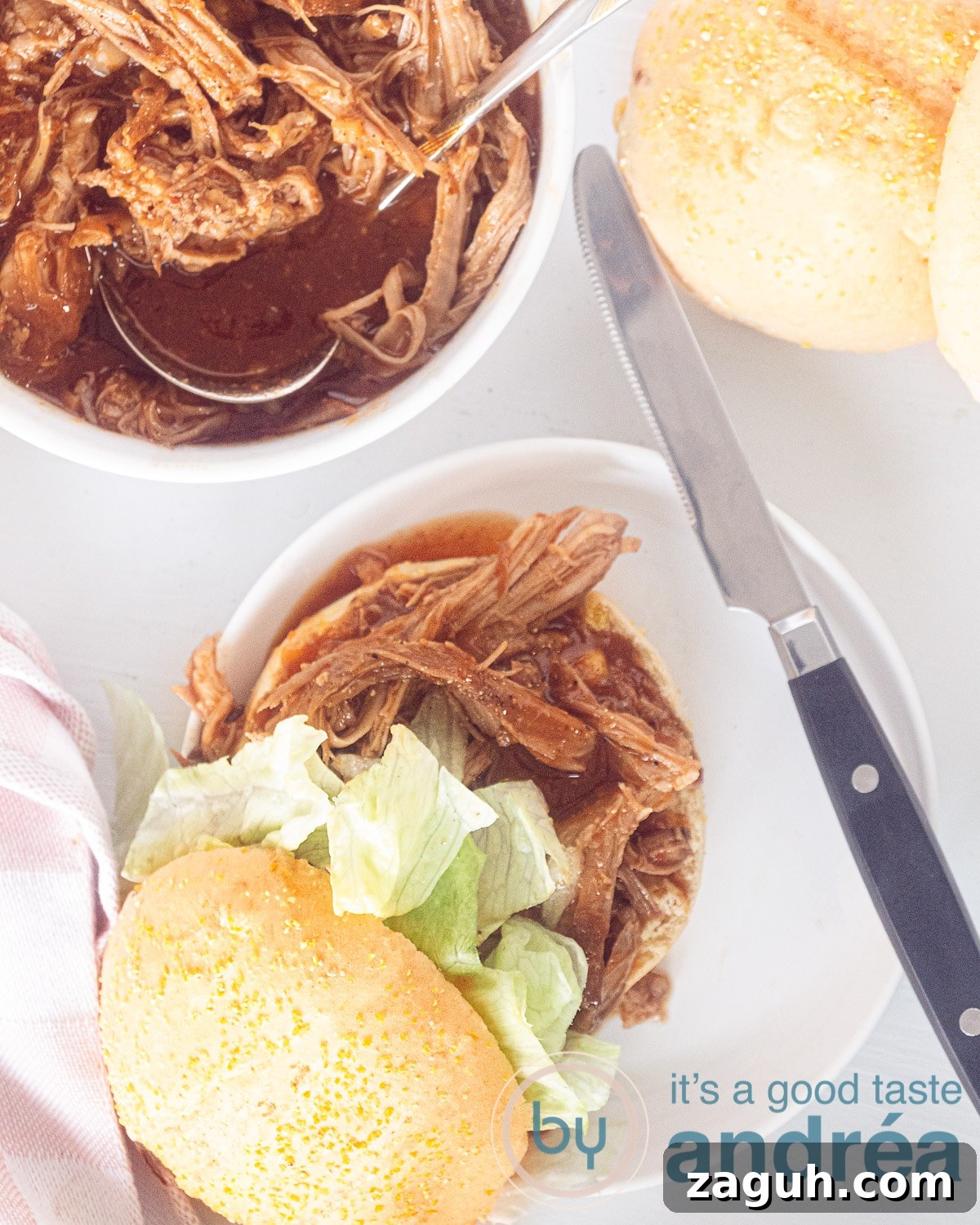 Slow Cooker Pulled Pork Buns Recipe for Tender, Juicy Sandwiches 5 A photo from above of a pulled pork sandwich, extra sandwiches and a bowl of pulled pork on a white background