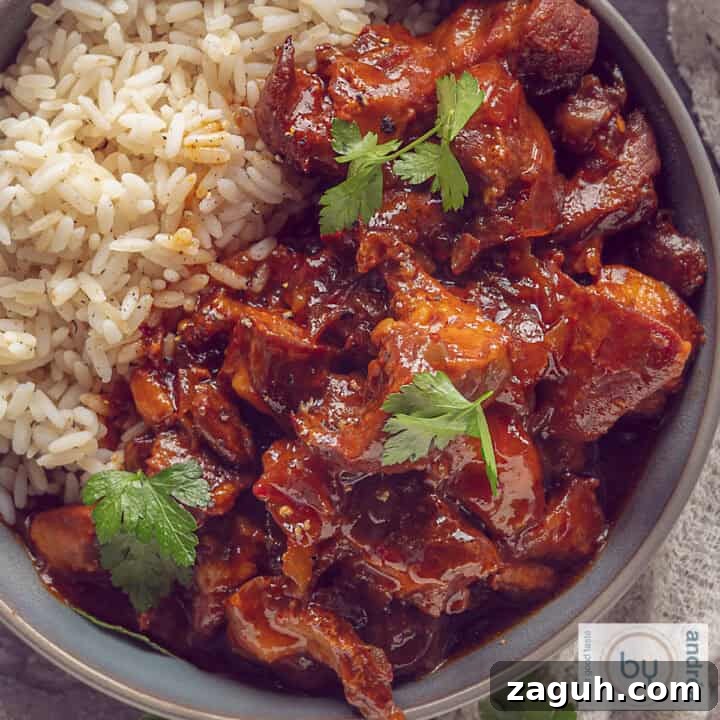 A square photo with a gray bowl with rice and ajam pangang.