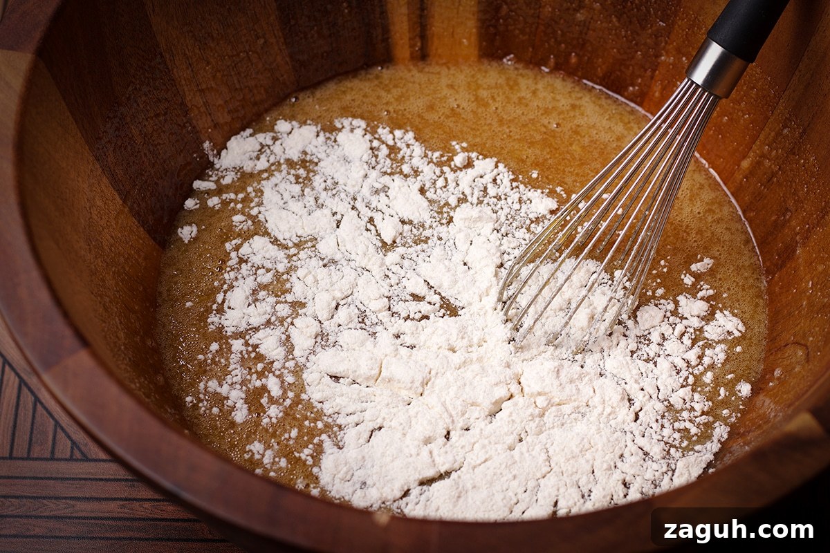 Pecan Pie Made Without Corn Syrup — Classic Recipe with Pure Maple 11 Someone using a wire whisk to mix flour into the rest of the pecan pie filling ingredients.