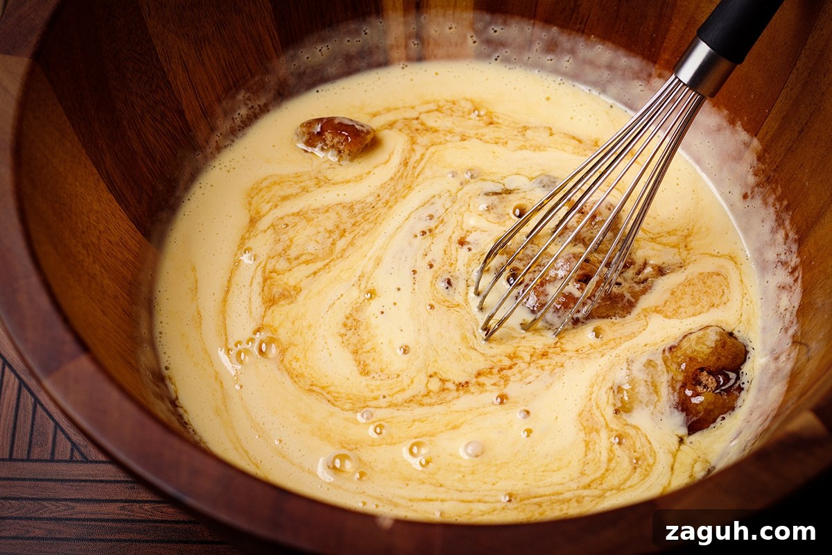 Pecan Pie Made Without Corn Syrup — Classic Recipe with Pure Maple 10 Someone using a wire whisk to mix brown sugar into beaten egg yolks.