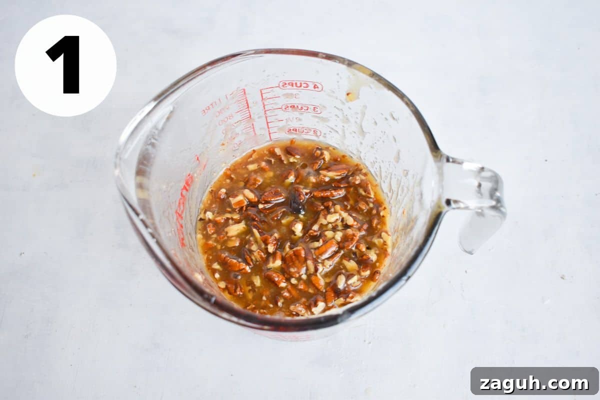 Sticky Pecan Upside-Down Cake Recipe for Moist, Caramelized Dessert 4 caramel pecan topping in glass measuring cup.