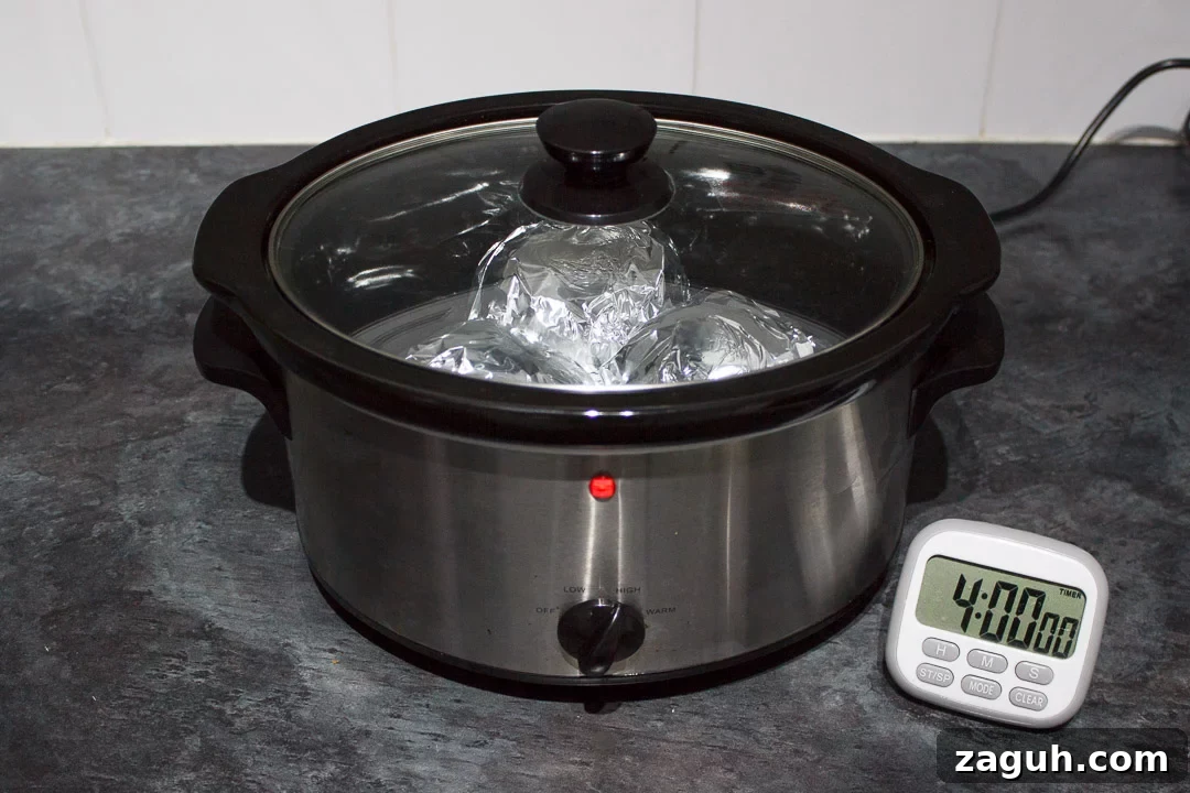 Slow Cooker Jacket Potatoes: Creamy Baked Potatoes Made Ahead 23 jacket potatoes wrapped in foil in a slow cooker