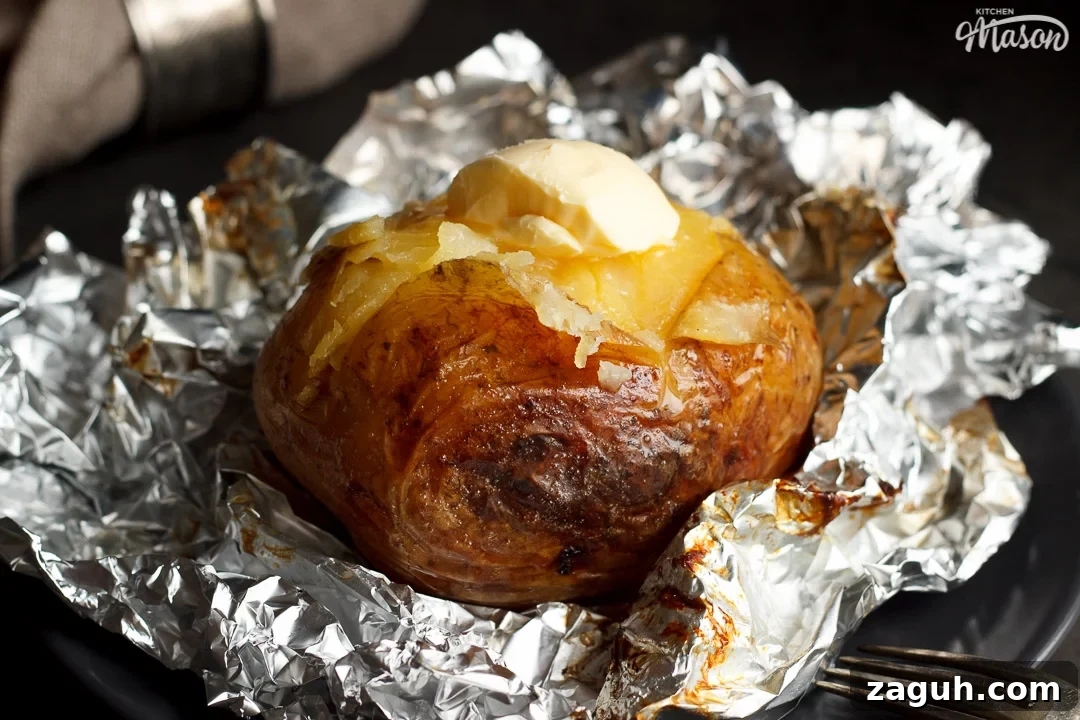 Slow Cooker Jacket Potatoes: Creamy Baked Potatoes Made Ahead 24 A slow cooker jacket potato on foil topped with melting vegan butter