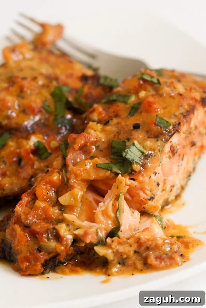Marry Me Salmon Recipe: Creamy Garlic Butter Salmon You'll Love 2 45 degree angle shot showing the flaky insides of a fillet of marry me salmon.