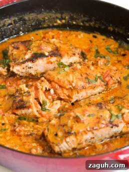 red skillet with creamy sun dried tomato salmon fillets.