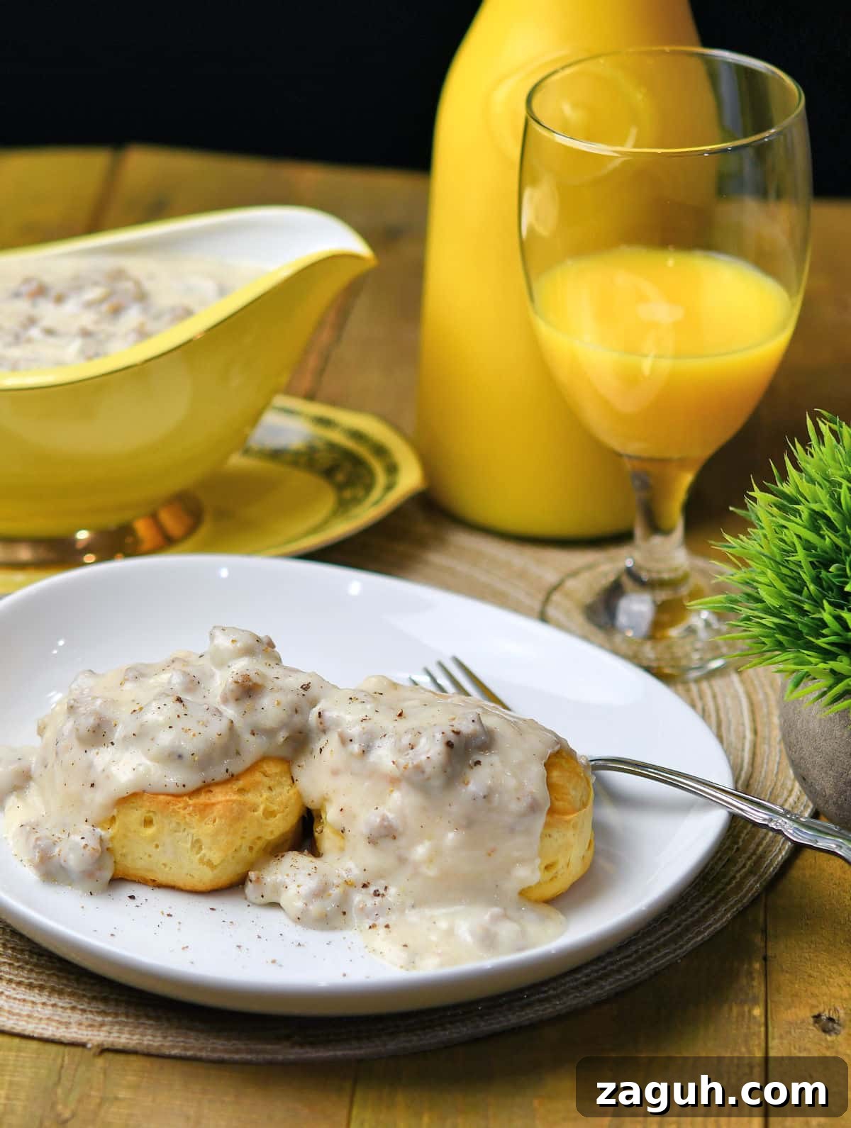 Southern Sausage Gravy Recipe with Biscuits — Classic Comfort Food 2 Homemade Sausage Gravy served on biscuits with glass of orange juice