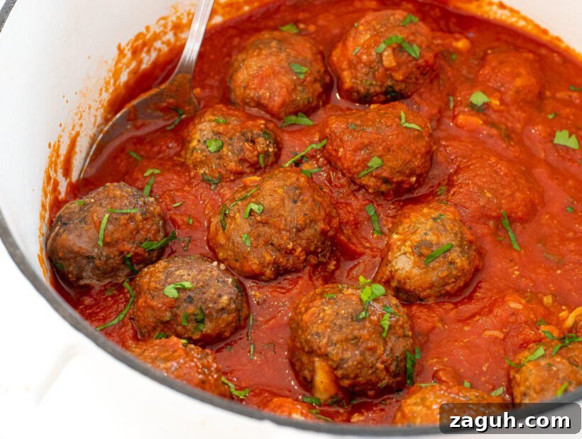 tomato sauce and meatballs in large cast iron white pot