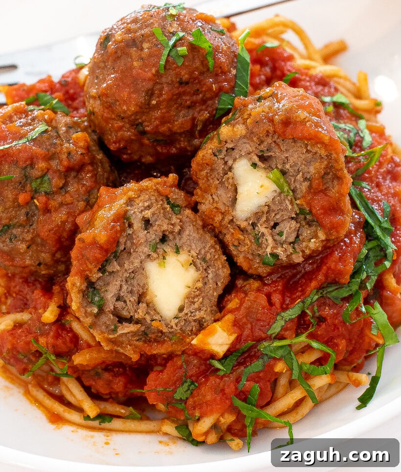 turkey pesto meatballs cut in half to show the cheese stuffed inside the meatballs