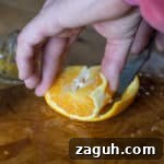 Removing the peel from an orange to make Candied Orange Peel