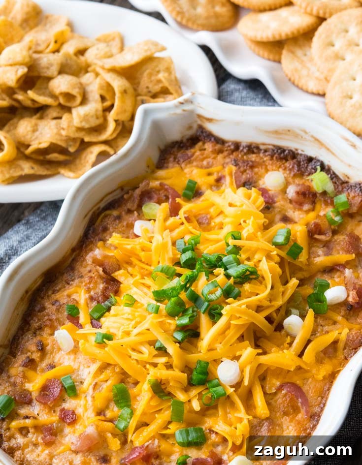 Crack Dip in a baking dish topped with shredded cheese