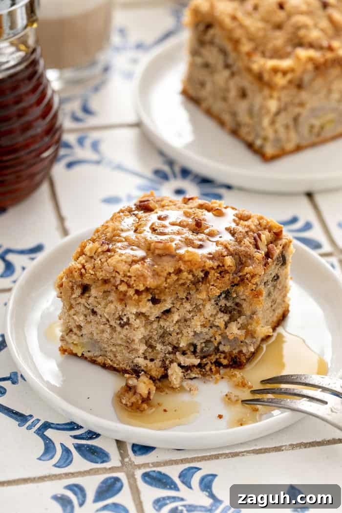 Make-Ahead Banana Coffee Cake Recipe for Perfect Morning Baking 11 Bite taken out of the corner of a piece of make-ahead banana coffee cake that has been drizzled with syrup