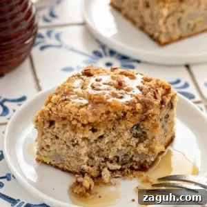 Make-Ahead Banana Coffee Cake Recipe for Perfect Morning Baking 12 Bite taken out of the corner of a piece of make-ahead banana coffee cake that has been drizzled with syrup