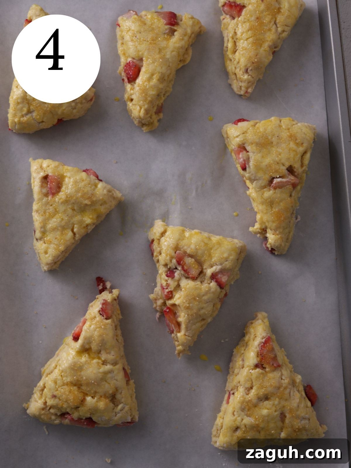 Flaky Strawberry Scones with Glaze — Homemade Recipe 7 Unbaked strawberry scones on baking sheet.