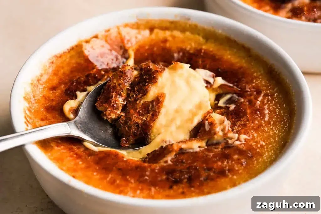 Pumpkin Creme Brulee Pumpkin creme brulee with a caramelized top, showing a spoon lifting a portion of the smooth, spiced custard