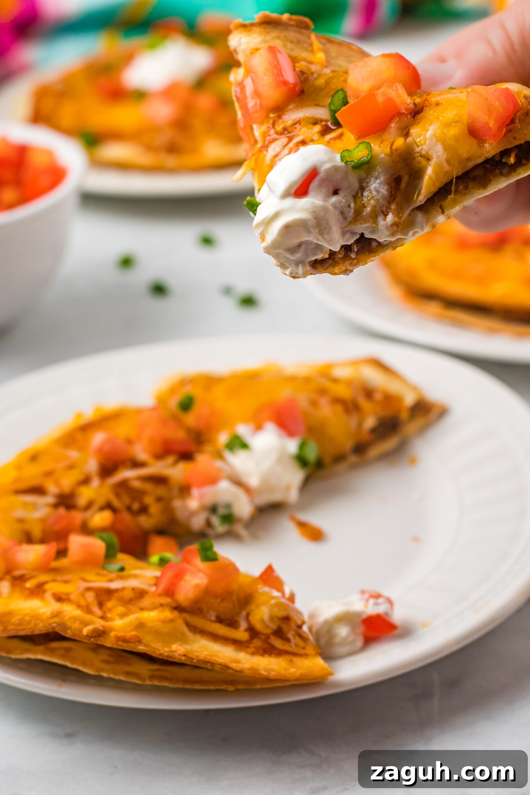 Taco Bell Mexican Pizza: How to Order, Ingredients & Nutrition Facts 5 Close up of a piece of pizza being removed from a white plate.