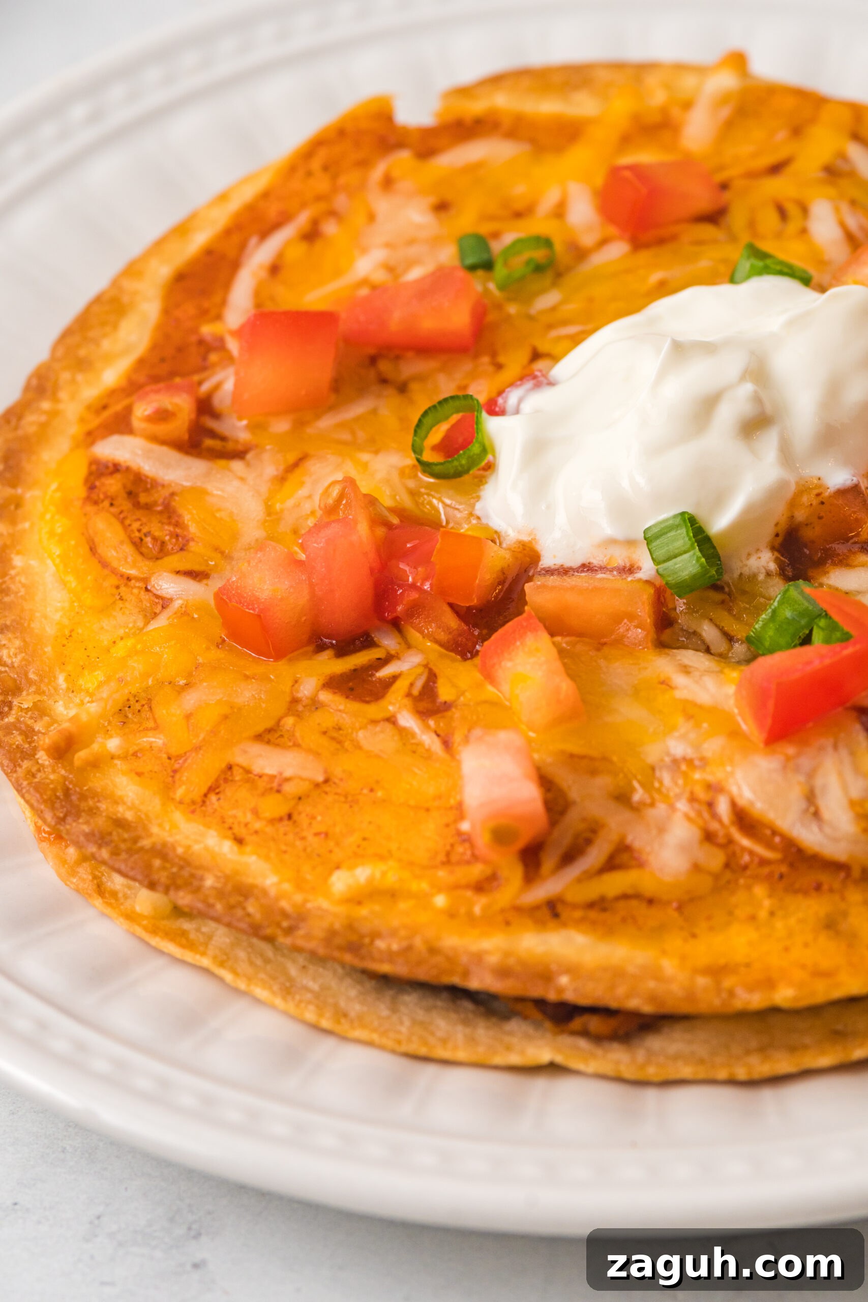 Taco Bell Mexican Pizza: How to Order, Ingredients & Nutrition Facts 9 up close shot of a mexican pizza topped with sour cream