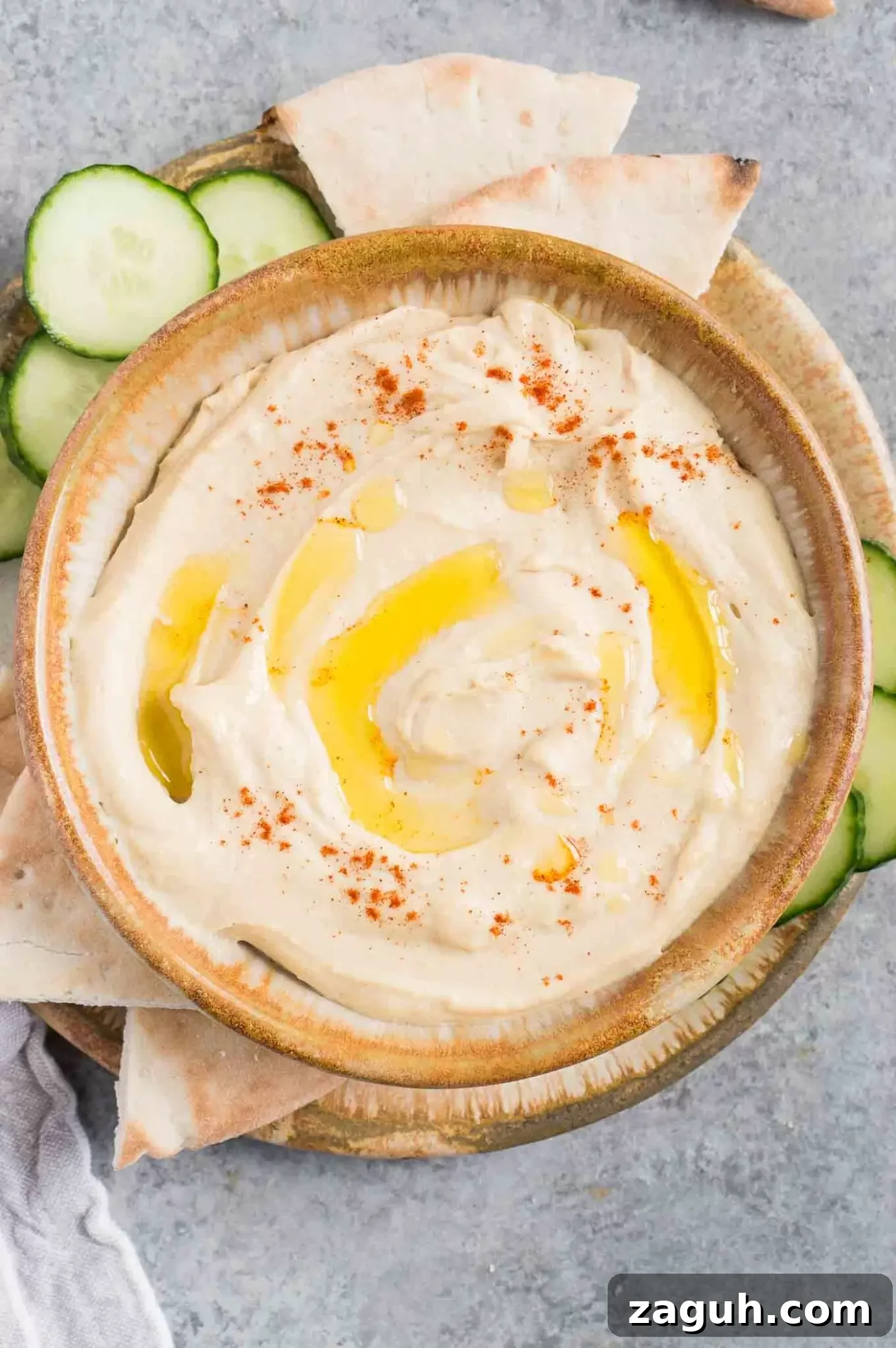 Creamy Homemade Hummus Recipe: Simple Chickpea Dip Tutorial 2 smooth and creamy hummus in a bowl with cucumbers and pita