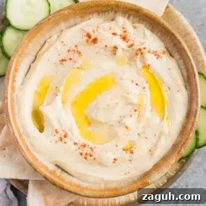 Creamy Homemade Hummus Recipe: Simple Chickpea Dip Tutorial 9 smooth and creamy hummus in a bowl with cucumbers and pita