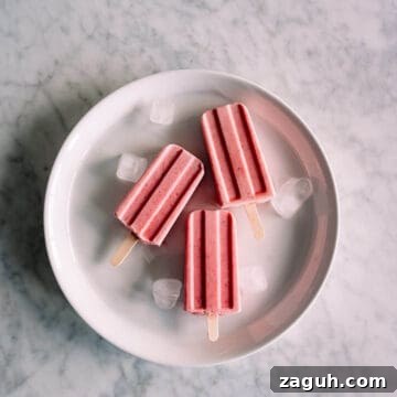 Strawberry Greek Yogurt Popsicles Recipe — Creamy Frozen Treats 15 3 strawberry popsicles on a white plate.