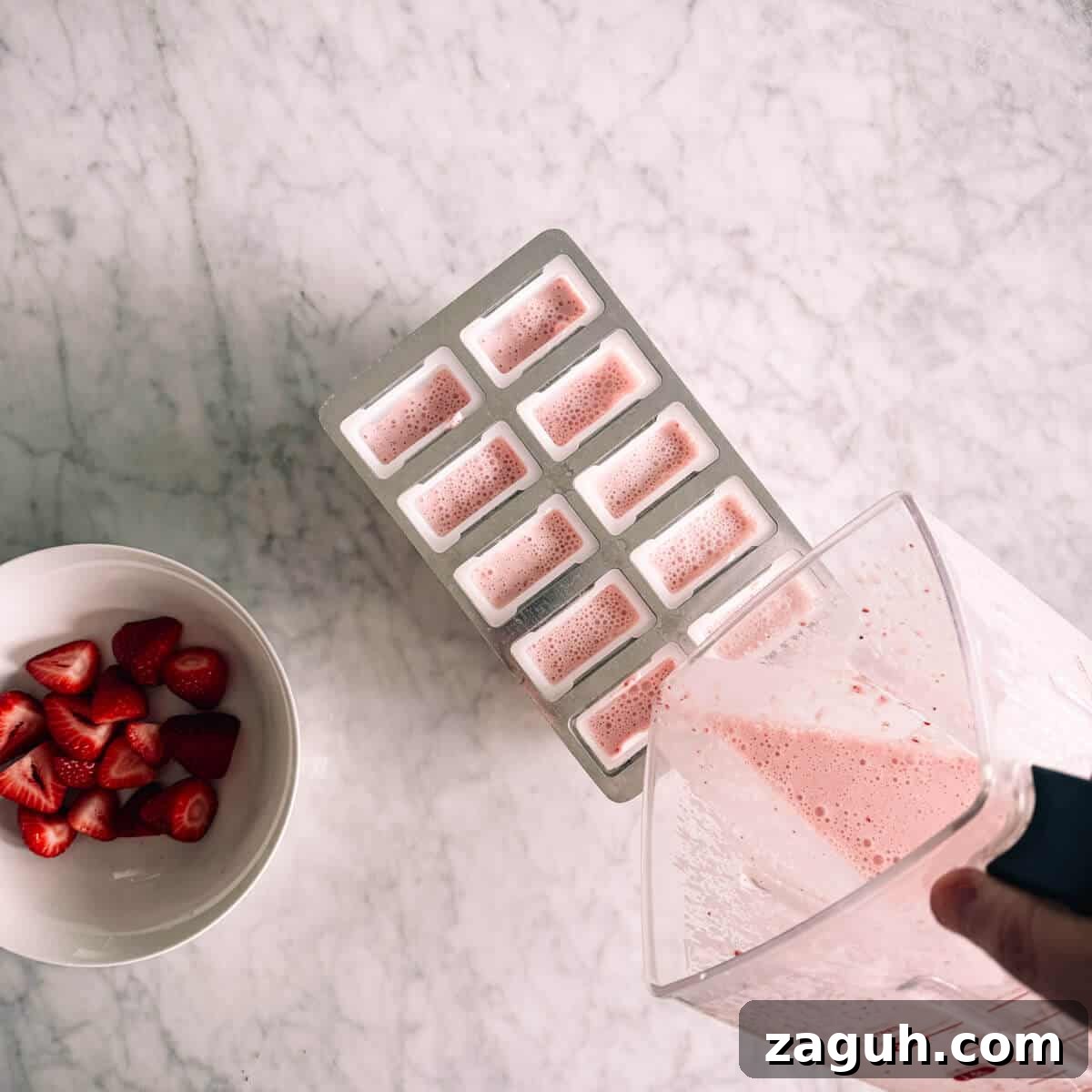Strawberry Greek Yogurt Popsicles Recipe — Creamy Frozen Treats 7 pouring liquid from a blender into a popsicle mold.