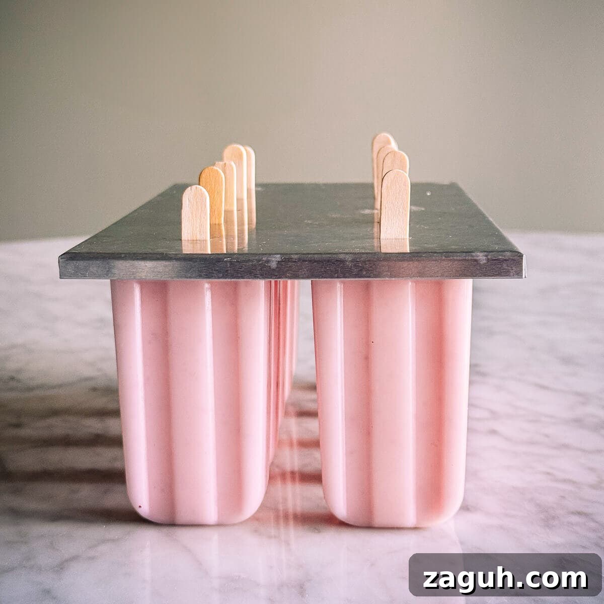 Strawberry Greek Yogurt Popsicles Recipe — Creamy Frozen Treats 8 popsicle molds holding popsicles.
