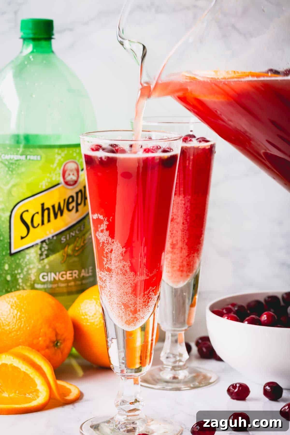 Sparkling Orange Cranberry Spritzer Recipe for Holiday Parties 3 Orange cranberry spritzer being poured into two glasses.