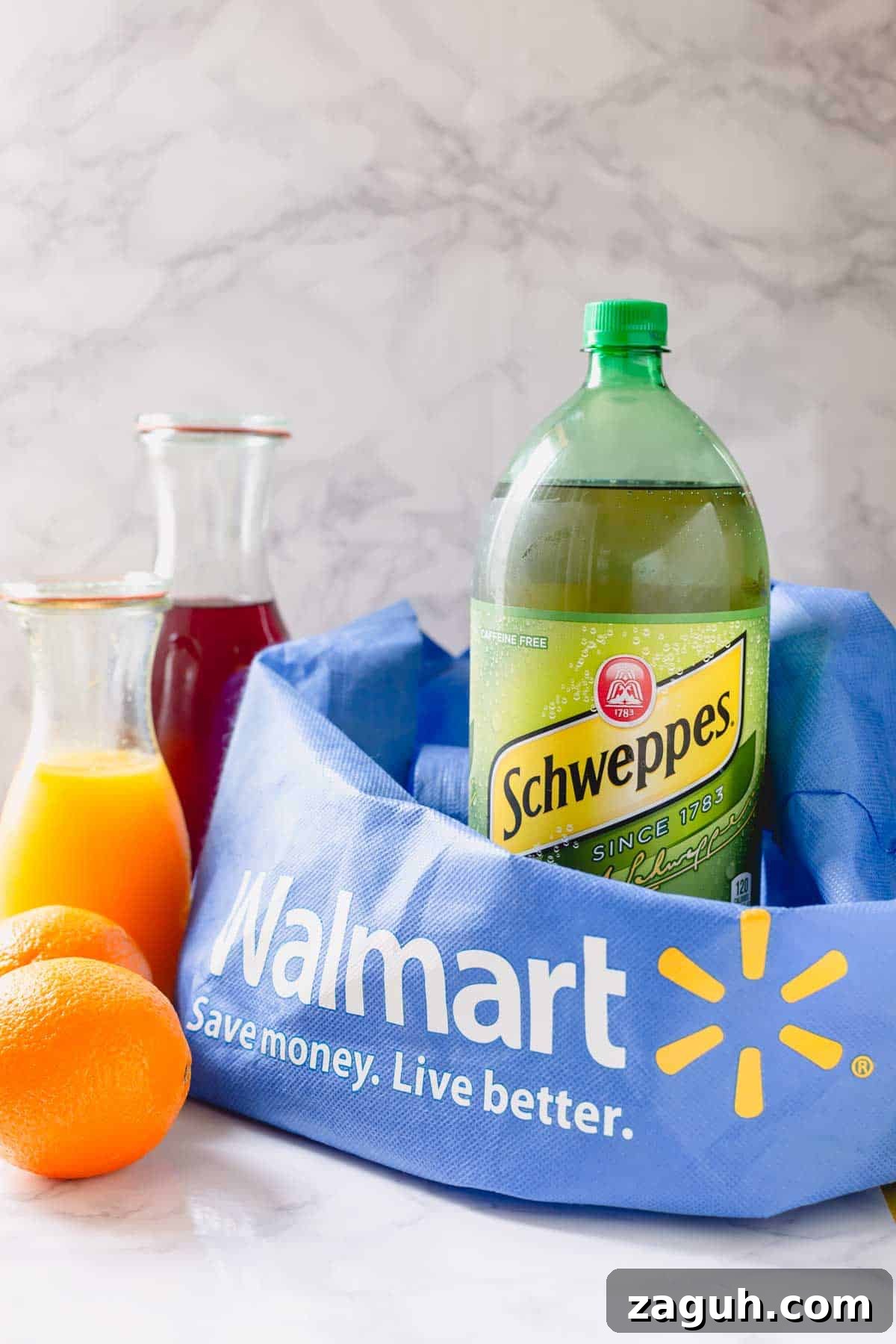 Sparkling Orange Cranberry Spritzer Recipe for Holiday Parties 4 Schweppes ginger ale, two oranges, orange juice, and pomegranate juice with a Walmart bag.