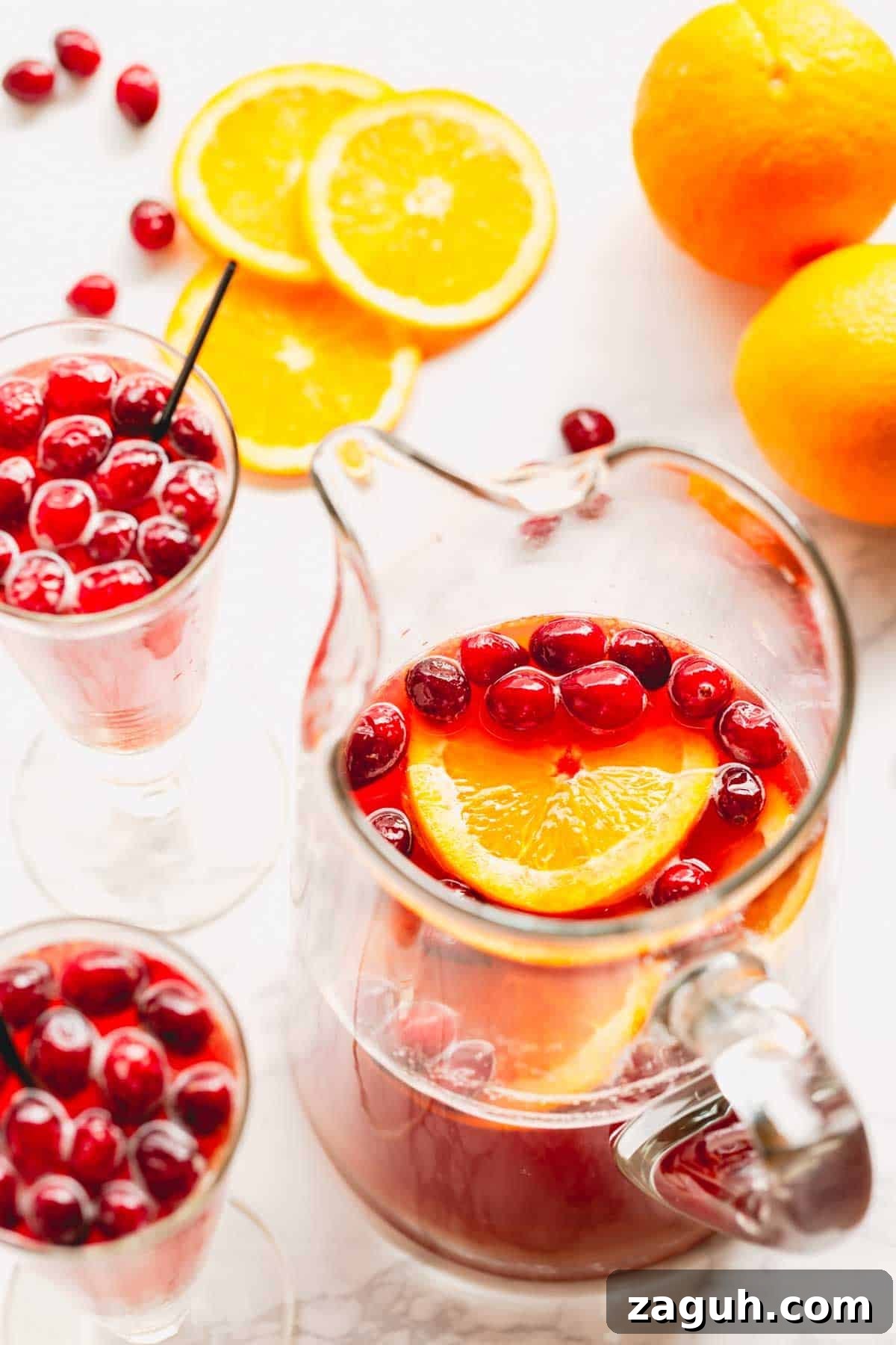 Sparkling Orange Cranberry Spritzer Recipe for Holiday Parties 9 Overhead image of two glasses of orange cranberry spritzer and a pitcher of the spritzer mix.