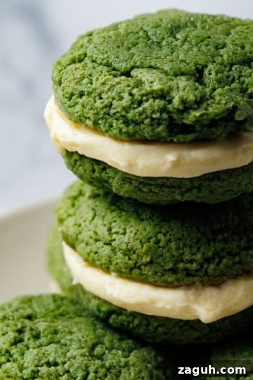 Stack of green whoopie pies with cream cheese filling on a white plate
