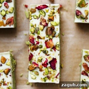 Homemade Pistachio Protein Bars Recipe for High-Energy Snacks 18 Close-up overhead view of single pistachio protein bar showing white chocolate coating with chopped pistachios and dried rose petal garnish