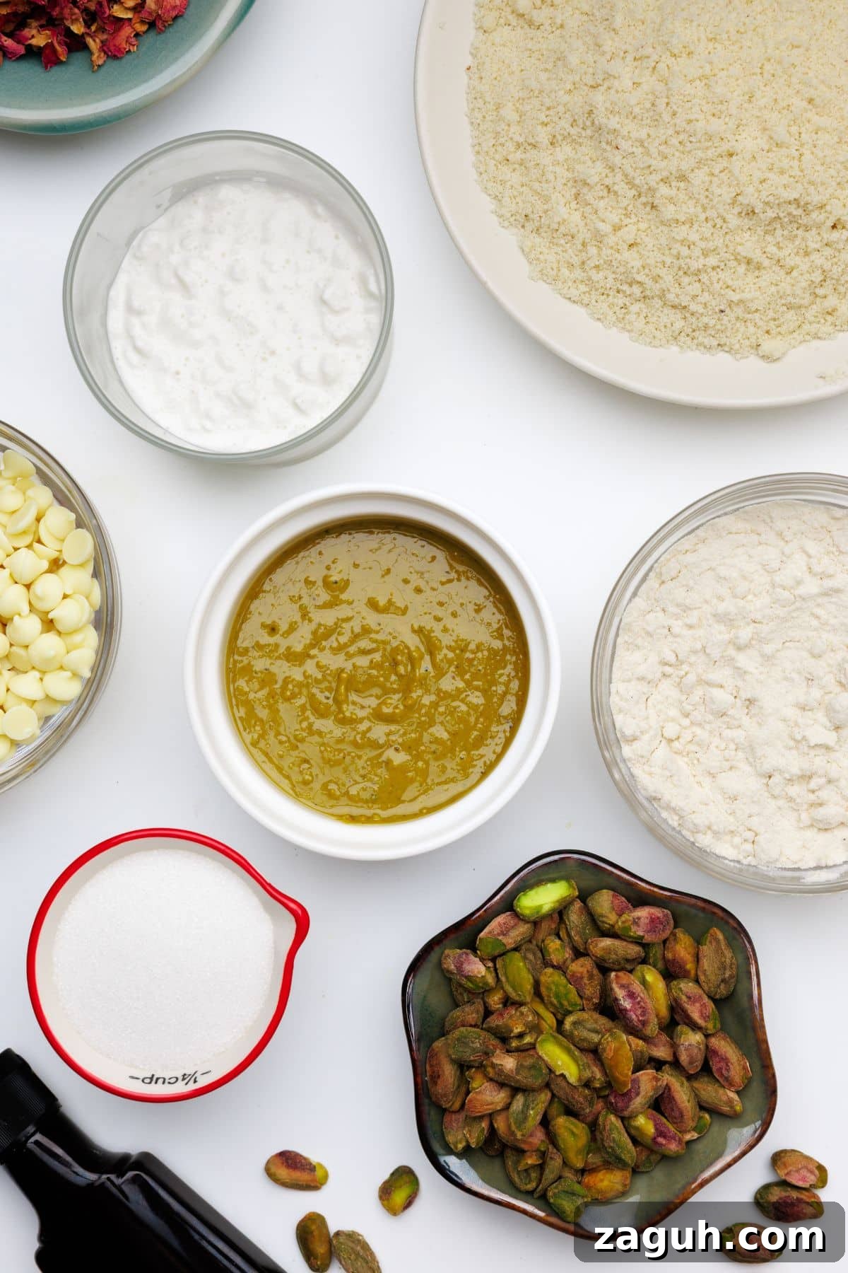 Homemade Pistachio Protein Bars Recipe for High-Energy Snacks 3 Overhead view of ingredients for pistachio protein bars including almond flour, protein powder, nut butter, white chocolate chips, pistachios, and Greek yogurt in separate bowls