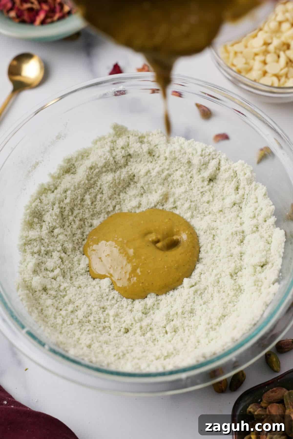 Homemade Pistachio Protein Bars Recipe for High-Energy Snacks 4 Nut butter being drizzled into bowl of almond flour and pistachio powder mixture