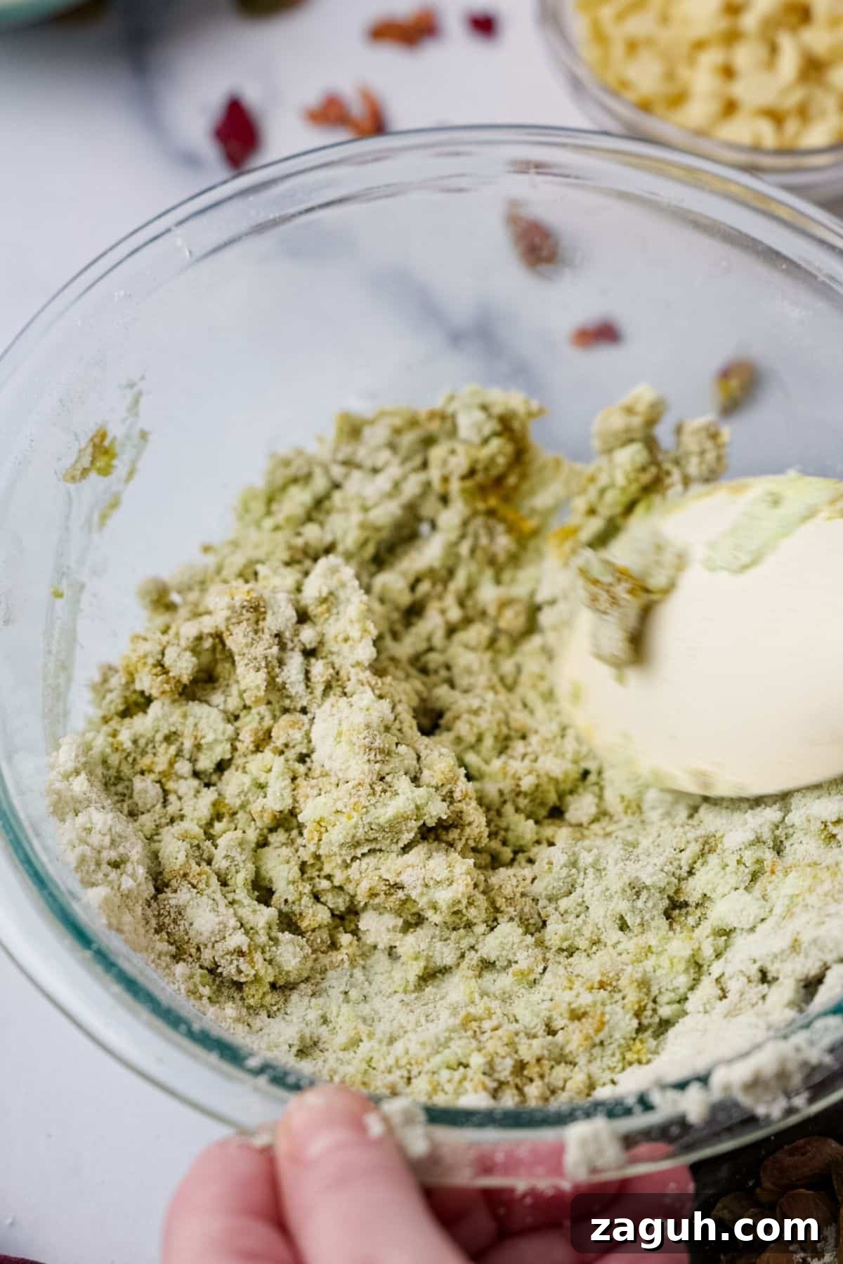 Homemade Pistachio Protein Bars Recipe for High-Energy Snacks 5 Green pistachio protein bar dough being mixed with white spatula in glass bowl