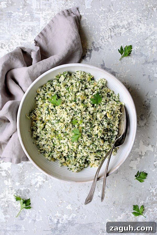 Cauliflower & Artichoke Tabbouleh: Fresh Low-Carb Salad Recipe 5 Photo of Cauliflower Artichoke Tabbouleh in white serving bowl garnished with parsley.
