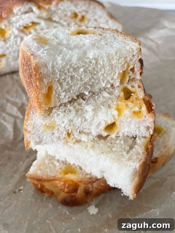 Three slices of Easy Cheesy Bread stacked offset on each other on parchment paper.