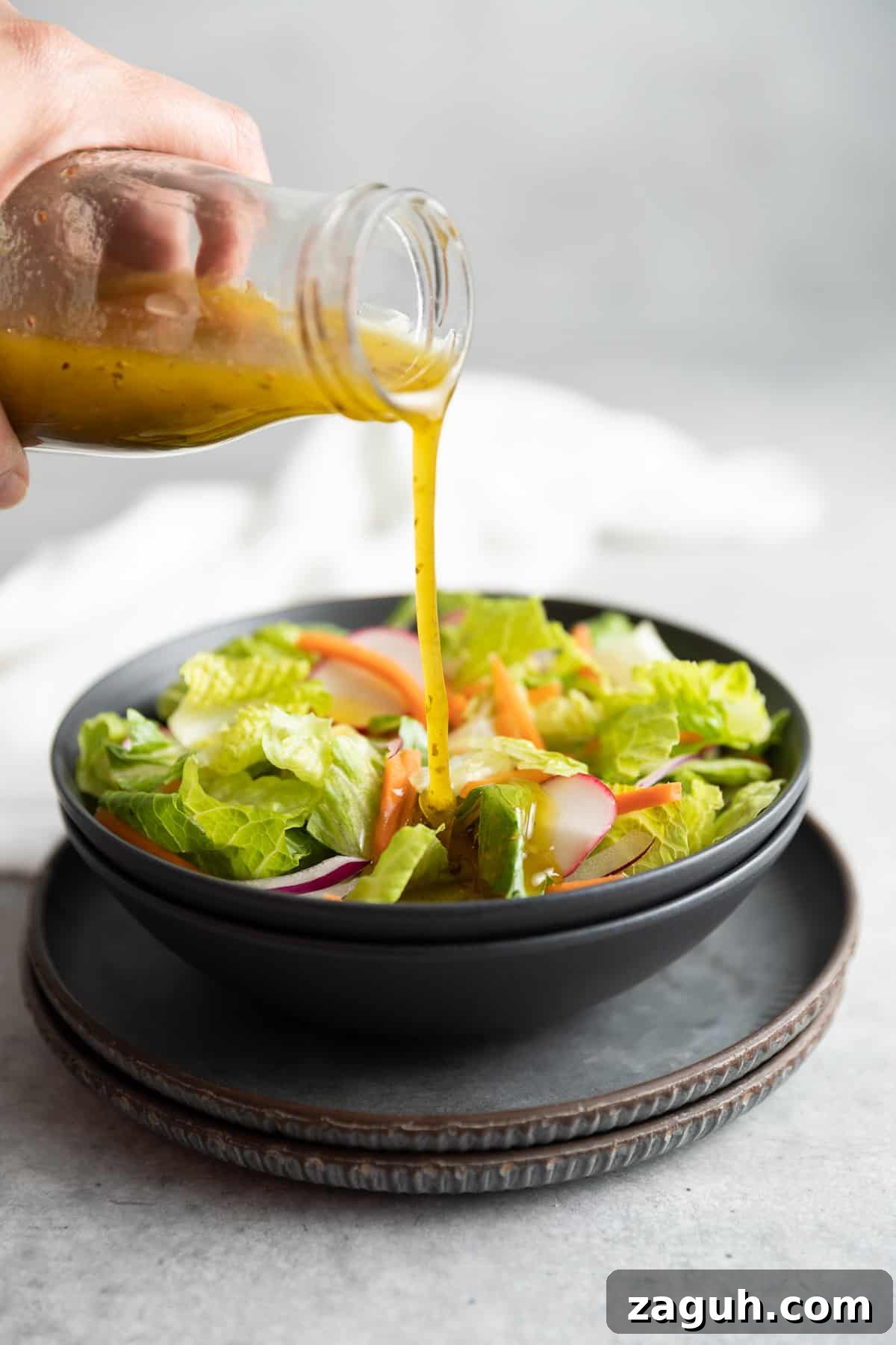 Authentic Italian Dressing Recipe for Fresh Flavor 2 Dressing being poured onto a salad.