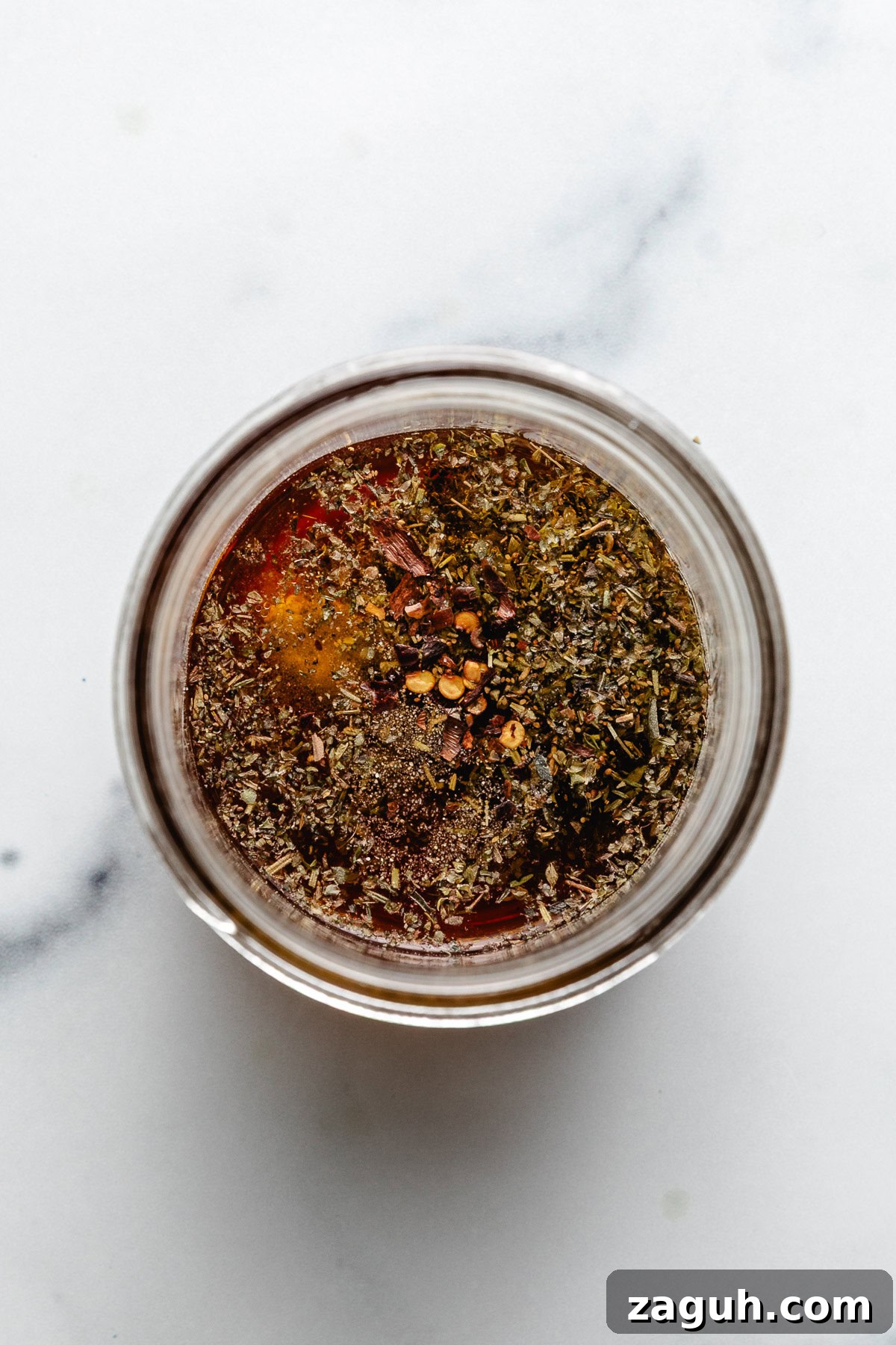 Authentic Italian Dressing Recipe for Fresh Flavor 4 Spices added to a jar from oil and vinegar.