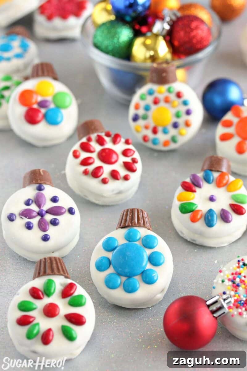 These cute Oreo Cookie Christmas Ornaments are a quick and easy holiday treat! They're a simple Christmas cookie even kids can help make. | From SugarHero.com Oreo Cookie Christmas Ornaments on a glittery background with colorful ornaments scattered around.
