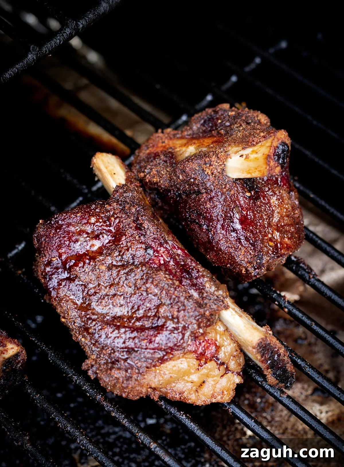 Perfectly Smoked Beef Short Ribs: Tender BBQ Recipe 15 Two beef short ribs on the smoker with bark.