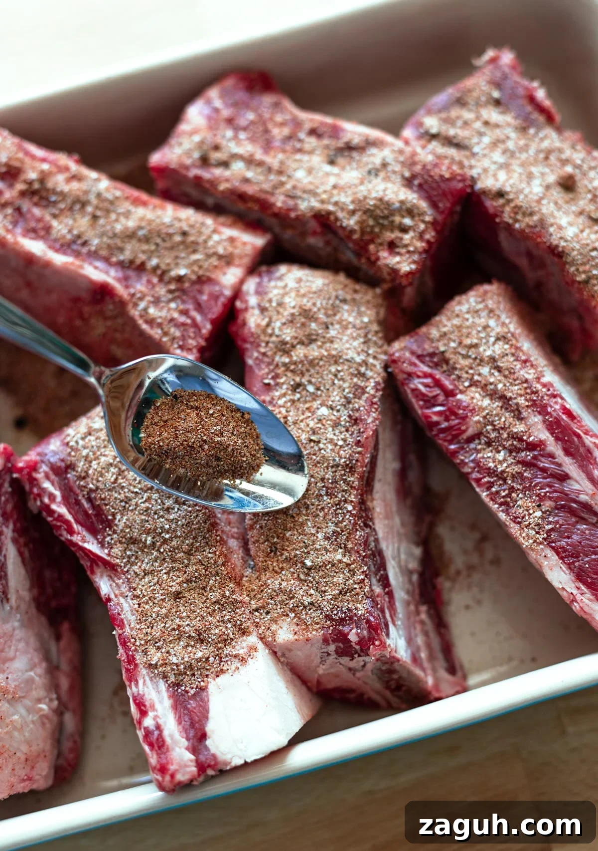 Perfectly Smoked Beef Short Ribs: Tender BBQ Recipe 9 Applying rub to ribs.