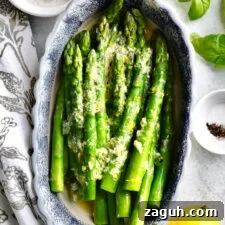 Quick Steamed Asparagus Recipe for Tender, Crisp Spears 12 Steamed asparagus in a blue and white oblong bowl.