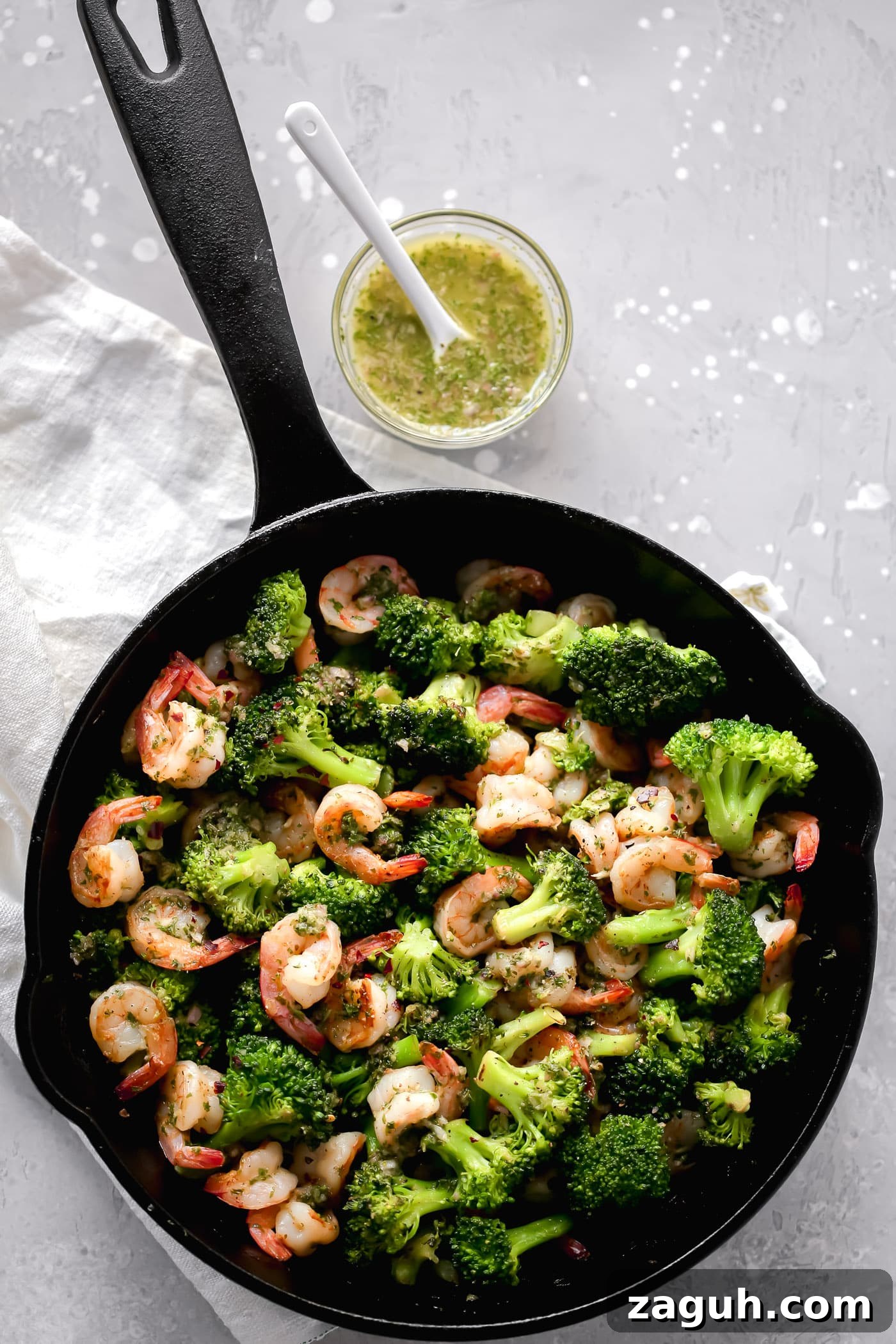 15 Whole30 Meal-Prep Recipes for Stress-Free Weekly Planning 11 An overhead view of a cast-iron skillet containing shrimp and broccoli.