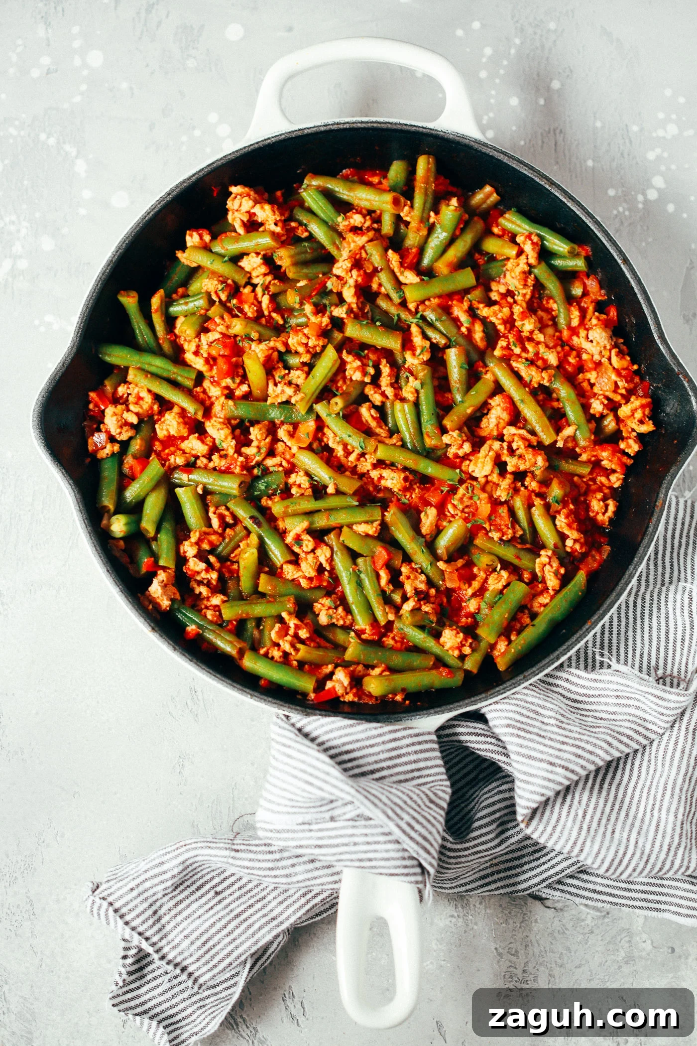 15 Whole30 Meal-Prep Recipes for Stress-Free Weekly Planning 7 An overhead view of a white skillet containing green beans and ground turkey.