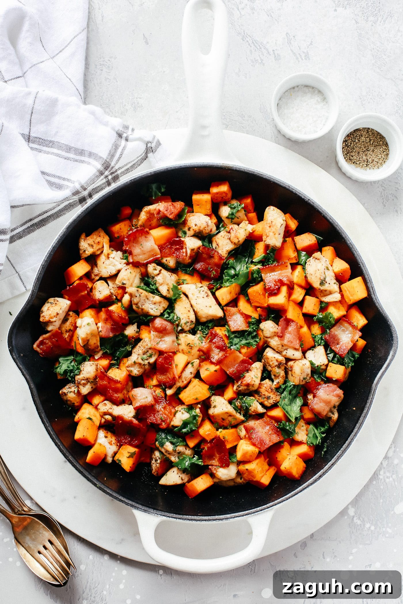 15 Whole30 Meal-Prep Recipes for Stress-Free Weekly Planning 8 An overhead view of a cast-iron skillet full of chicken, sweet potatoes, kale, and bacon.