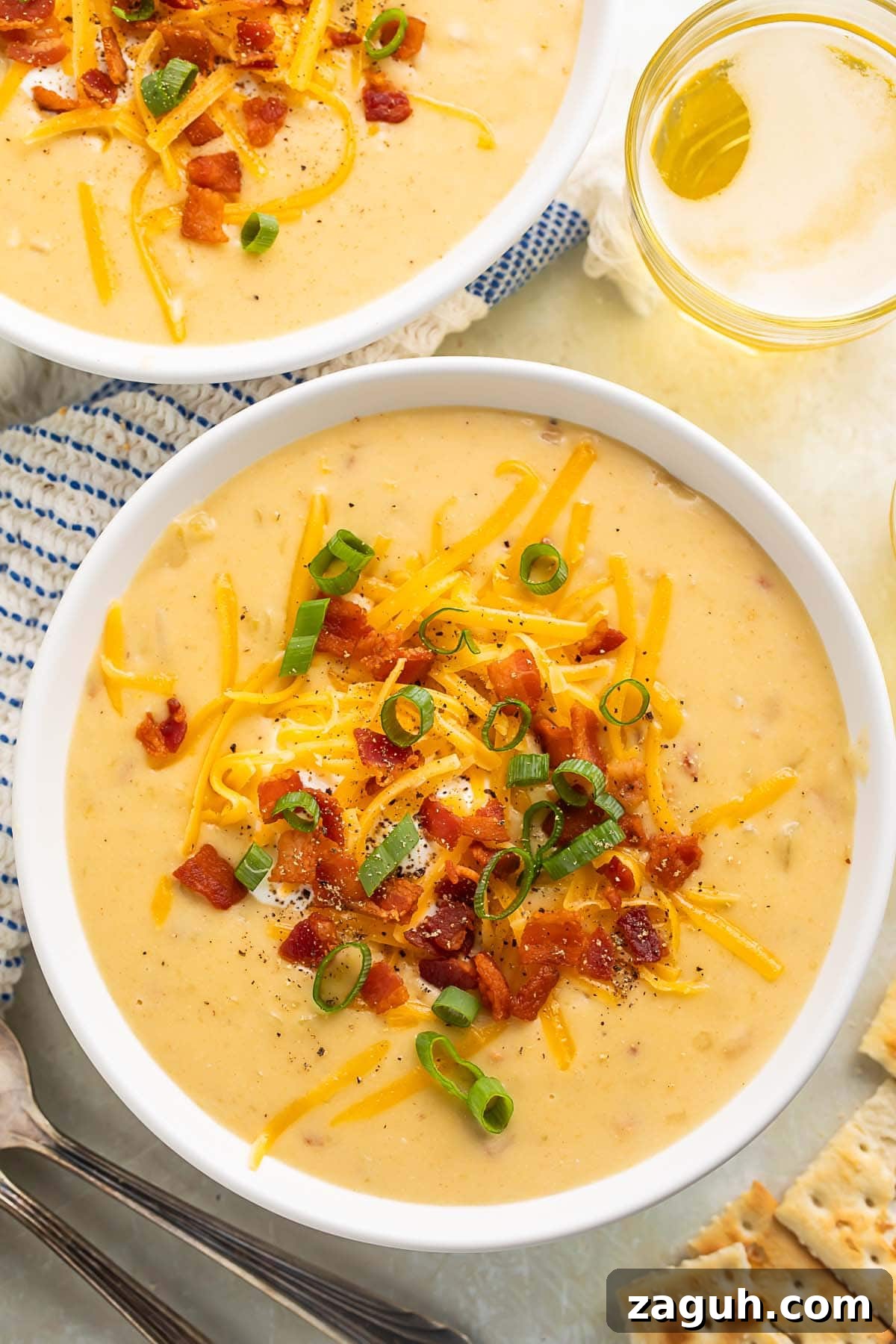 Creamy Gluten-Free Potato Soup Recipe for Cozy Weeknights 3 Two bowls of gluten free potato soup topped with chopped bacon, shredded cheese, and sliced green onions.