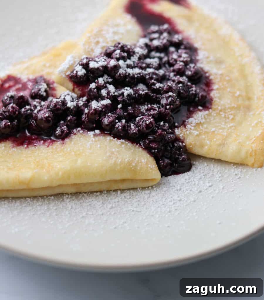Swedish Pancakes with Vanilla Pastry Cream & Blueberry-Cardamom Compote 8 Swedish pancakes on a plate with blueberry compote